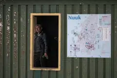 Seorang individu menunggu di dalam hentian bas yang ditandai dengan papan tanda laluan di Nuuk, Greenland, pada 22 Januari 2026.