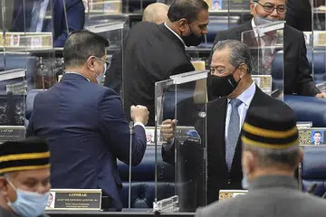 DAPAT SOKONGAN AWAL: Tan Sri Muhyiddin (kanan) berinteraksi dengan Menteri Perdagangan Dan Perusahaan Antarabangsa Azmin Ali di parlimen semalam. Belanjawan pertama yang diusul Tan Sri Muhyiddin diluluskan di peringkat dasar semalam. - Foto EPA-EFE