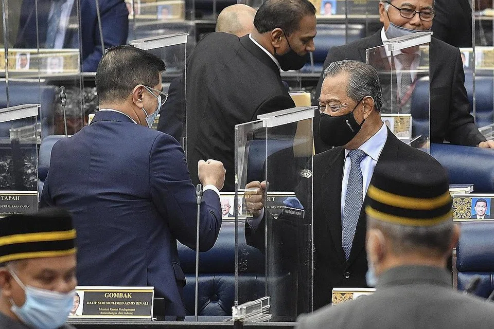 DAPAT SOKONGAN AWAL: Tan Sri Muhyiddin (kanan) berinteraksi dengan Menteri Perdagangan Dan Perusahaan Antarabangsa Azmin Ali di parlimen semalam. Belanjawan pertama yang diusul Tan Sri Muhyiddin diluluskan di peringkat dasar semalam. - Foto EPA-EFE