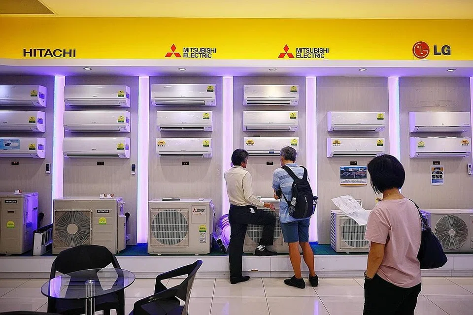 AKIBAT GELOMBANG PANAS: Pelanggan meninjau unit alat hawa dingin di Gain City di cawangan Sungei Kadut. Cuaca panas yang melanda Singapura dipercayai mendorong kenaikan permintaan tenaga dan harga elektrik. - Foto ST