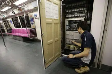 Seorang kontraktor menunjukkan sistem pengisyaratan baru dipasang di dalam kabin kereta api semasa ujian bagi Laluan Utara-Selatan antara stesen Admiralty dan Yew Tee.