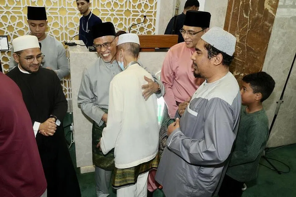 JALINAN UKHUWAH: Menteri Bertanggungjawab bagi Ehwal Masyarakat Islam, Encik Masagos Zulkifli Masagos Mohamad (dua dari kiri), bersalaman dengan para jemaah selepas menunaikan sembahyang sunat Aidilfitri di Masjid Al-Muttaqin di Ang Mo Kio Avenue 6 dengan diperhatikan Mufti Dr Nazirudin Mohd Nasir. - Foto