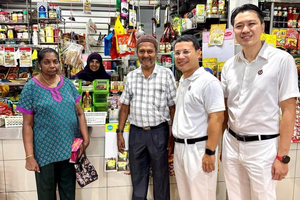 Calon GRC West Coast-Jurong West yang juga Menteri Pembangunan Negara, Encik Desmond Lee (dua dari kanan), dan calon sepasukan, Setiausaha Parlimen Kanan (Kewangan merangkap Pendidikan), Encik Shawn Huang (kanan), bertemu penduduk semasa lawatan ke Pusat Makanan dan Pasar Taman Jurong.