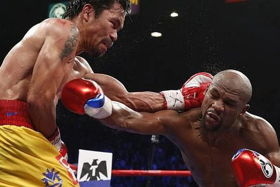 PERTARUNGAN DUA GAYA BERBEZA: Sedang Floyd Mayweather Jr (kanan) lebih banyak memanfaatkan skil 'pertahanan' namun tumbukankilatnya sering mendarat ke badan pencabarnya, Manny Pacquiao yang terkenal dengan gayanya lebih berani dan lebih gemar menyerang. - Foto-foto AFP
