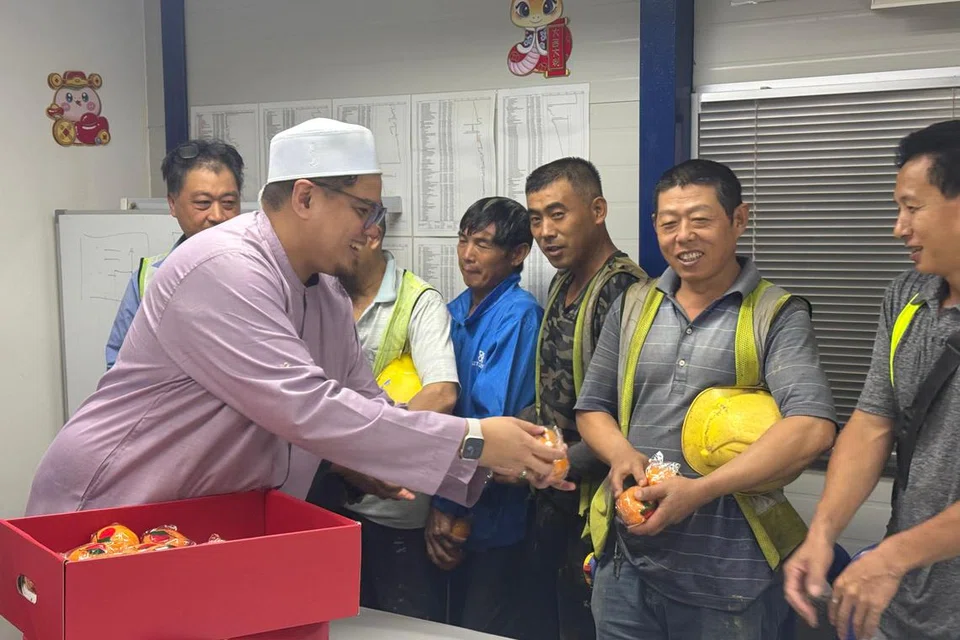 Pengurus Masjid An-Nahdhah, Ustaz Zulhilmi Mohamed (kiri), memberi limau kepada pekerja asing di tapak binaan Projek Bina Ikut Tempahan (BTO) Bishan Ridges, berhampiran Masjid An-Nahdhah.
