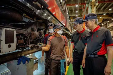 SUMBANGAN PEKERJA: Kakitangan penyelenggaraan SMRT menunjukkan Encik Seah Moon Ming (paling kanan) dan Encik Ngien Hoon Ping (dua dari kanan) salah satu projek Kaizen mereka - inisiatif asas SMRT menjadikan proses kerja lebih selamat dan cekap - di Depoh Kim Chuan yang juga depoh kereta api bawah tanah terbesar di dunia. - Foto-foto SMRT