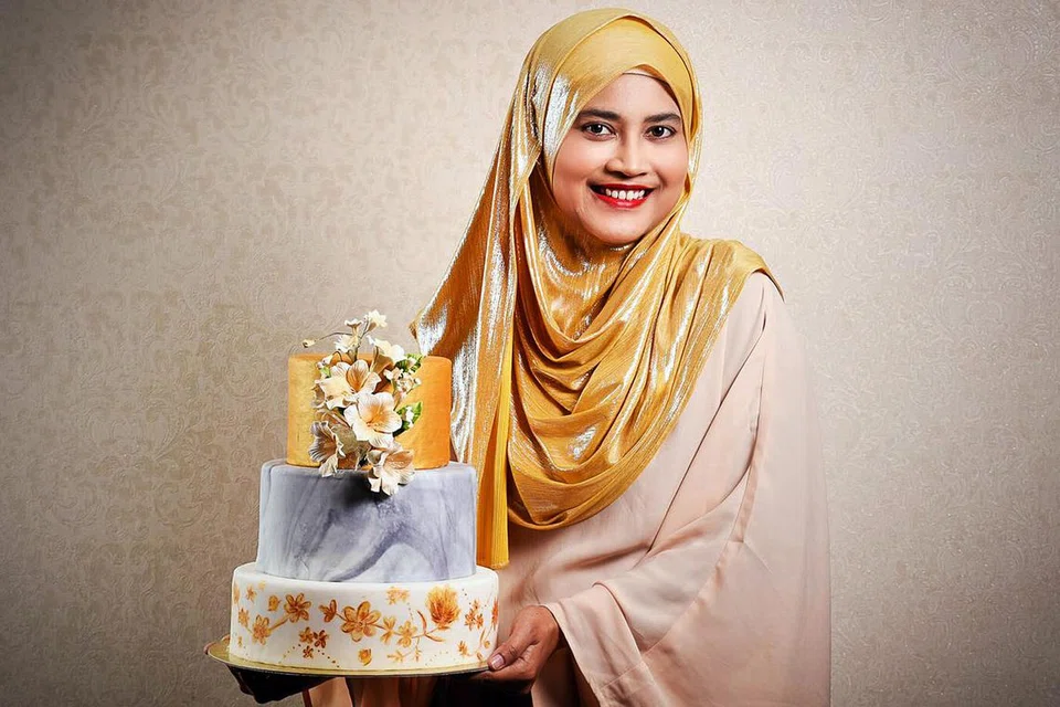 KEK KESAN CAT AIR: Cik Suhaila Othman kini ingin memperbaiki hiasan kek dengan kesan cat air atau 'water colour effect' seperti kek yang ditatangnya. Gambar sisipan pula menunjukkan kek perkahwinan pertama rekaannya buat adik ipar lelakinya pada 2014. - Foto JULY PHOTOGRAPHY 