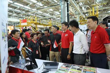 BINA PEMIKIRAN DENGAN MATLAMAT MASA DEPAN DIGITAL: Encik Ng (tiga dari kanan) meninjau teknologi yang ada dalam dunia pengangkutan setempat sewatu melancarkan rancangan SkillsFuture digital buat pekerja SMRT. Bersamanya ialah Penolong Setiausaha Agung NTUC, Encik Melvin Yong (kanan). - Foto NTUC