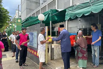 Pengerusi Eksekutif Kanan, Ustaz Mohamed Ali Atan (tiga dari kanan, bersongkok) sedang mengagihkan bubur masjid kepada orang ramai, selepas solat Asar. 