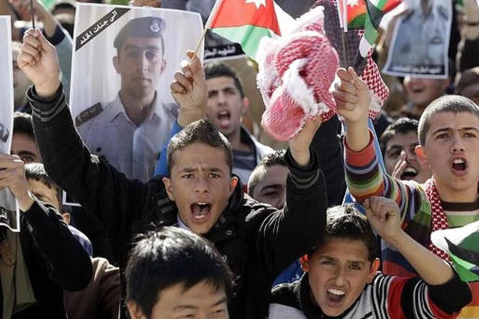TOLAK PENGGANASAN: Warga muda Jordan bersorak semasa mengadakan bantahan terhadap Daesh, atau IS, di Amman pada Februari 2015 dan tindakan kumpulan militan itu membakar hidup-hidup seorang juruterbang negara mereka, Encik Maaz al-Kassasbeh. - Foto fail AFP