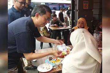 SEBAR KESEDARAN: Dr Muhammad Faishal Ibrahim berinteraksi dengan orang awam di Kampong Gelam dalam satu sesi pendekatan mengenai kempen 'Dadah Itu Haram' - Foto BH oleh IRMA KAMARUDIN