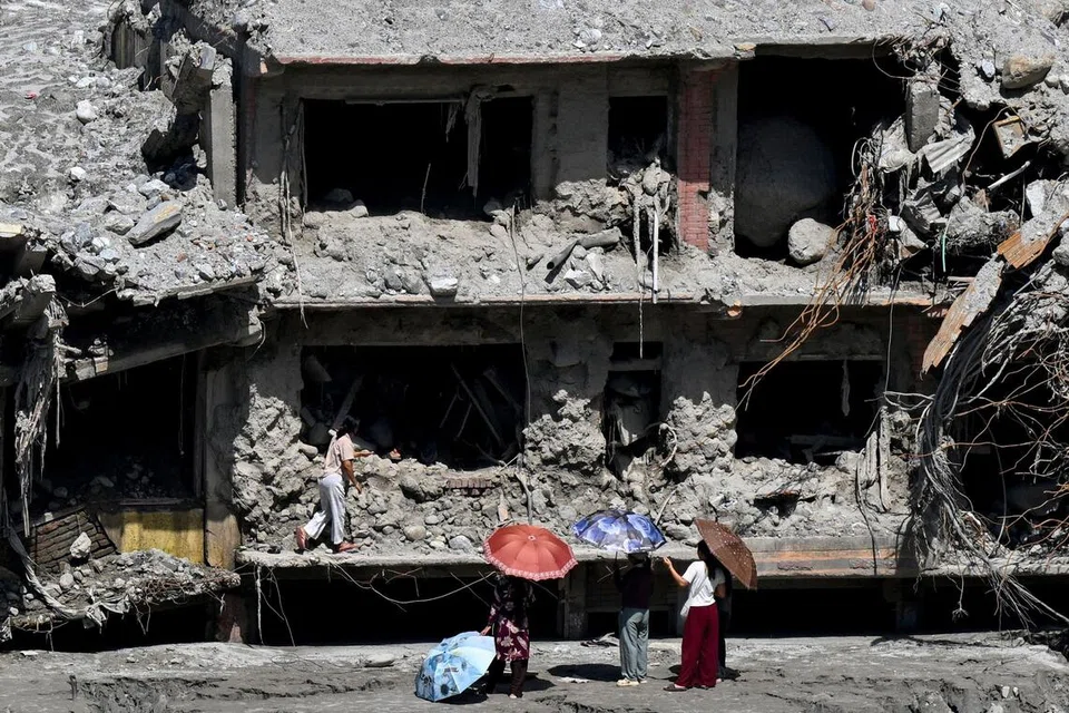 Penduduk melihat sebuah rumah yang rosak akibat banjir kilat pada 26 Ogos di Trishuli, daerah Nuwakot, Nepal, pada 22 September 2026. Nepal kini menamatkan operasi mencari dan menyelamat secara aktif, 40 hari selepas bencana itu meragut sekurang-kurangnya 1,455 nyawa, dengan 5,285 orang masih hilang, dan mengalihkan tumpuan kepada usaha pemulihan dan pembinaan semula.