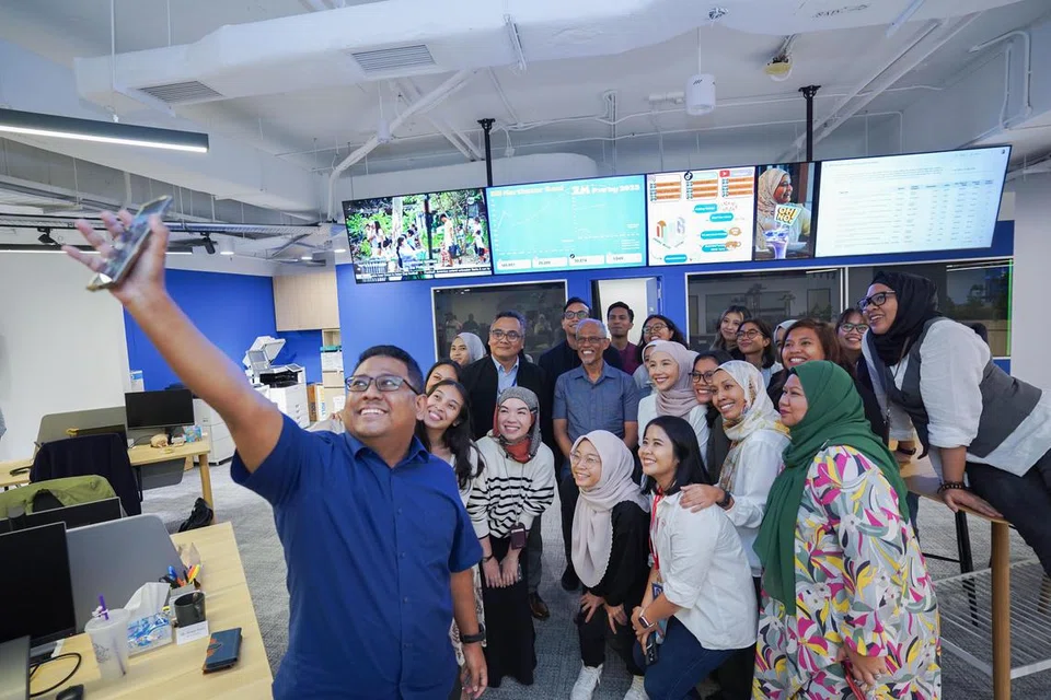 SWAFOTO BERSAMA: Encik Masagos Zulkifli  (tengah, baju kelabu) bergambar bersama Editor Berita Harian (BH), Encik Nazry Mokhtar (di kanan beliau), dan kakitangan BH ketika beliau mengunjungi bilik berita BH pada 17 Januari. 
