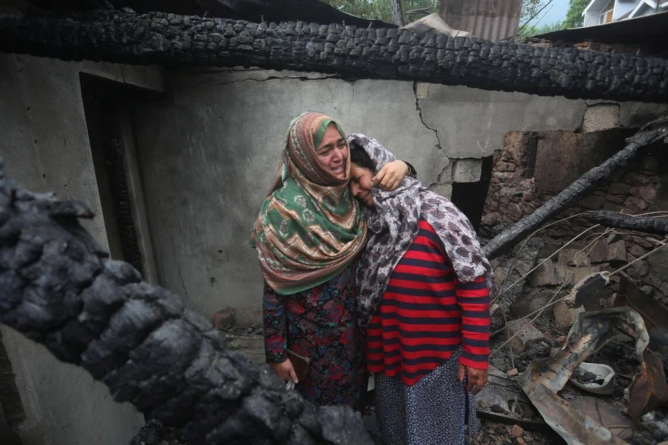 Dua wanita Kashmir meratap di dalam rumah mereka yang rosak akibat bedilan rentas sempadan dari Pakistan, di kampung Salamabad di Uri, utara Srinagar, ibu kota Kashmir, India pada 8 Mei.