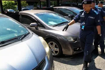 Pengarah Jabatan Kastam Diraja Malaysia (JKDM) Kelantan, Wan Jamal Abdul Salam Wan Long (depan) memeriksa kenderaan seludup dari Singapura yang dirampas di Pejabat Penguatkuasaan JKDM Kota Bharu, Kelantan.