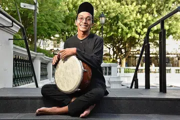KEWAJIPAN HIDUPKAN BUDAYA SENDIRI: Pemain rebana kumpulan Orkestra Sri Temasek, Encik Azim Azman, tertarik pada keunikan dan keistimewaan bunyi alat muzik tradisional itu. - Foto BH oleh DESMOND WEE