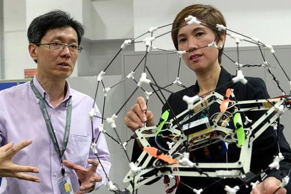 SELAMI KECANGGIHAN: Cik Josephine Teo (kanan) dibawa melihat pelbagai kemudahan dan peralatan di Akademi Penerbangan Temasek termasuk dron yang operasinya sedang dijelaskan Pengurus Kursus Kejuruteraan Aeroangkasa di Politeknik Temasek, Encik Yue Keng Mun. - Foto-foto TAUFIK A. KADER