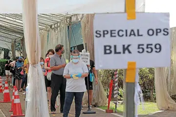JALANI UJIAN SWAB: Penduduk di Blok 559 di Pasir Ris menjalani ujian swab di bekas Sekolah Rendah Coral kelmarin. - Foto ZAOBAO