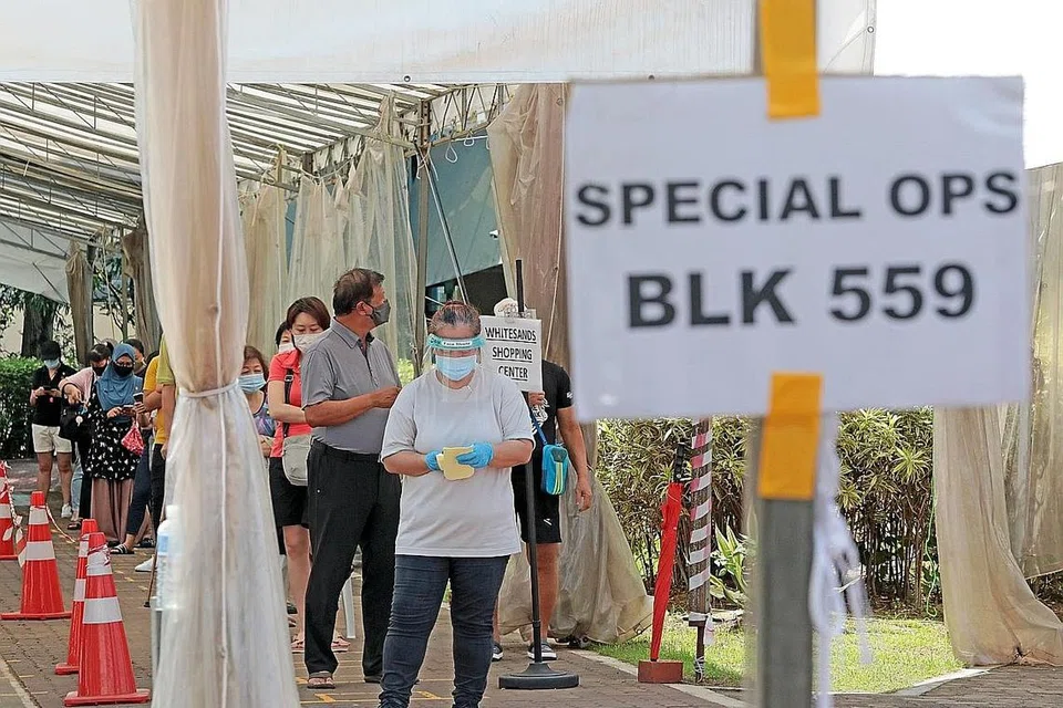 JALANI UJIAN SWAB: Penduduk di Blok 559 di Pasir Ris menjalani ujian swab di bekas Sekolah Rendah Coral kelmarin. - Foto ZAOBAO