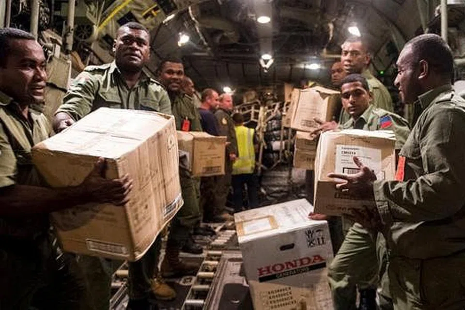 AGIHKAN BANTUAN: Bekalan bantuan termasuk alat jana kuasa, bekalan makanan dan minuman dibawa keluar tentera Fiji daripada sebuah pesawat C-130 milik Tentera Udara Diraja New Zealand. - Foto REUTERS
