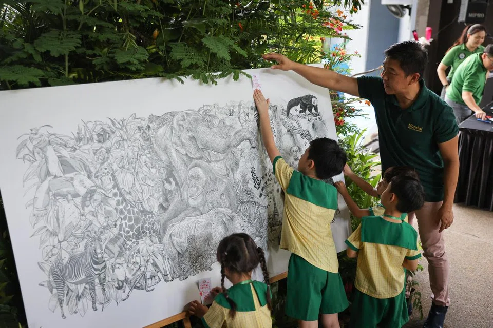 RAIKAN LIMA DEKAD: Timbalan Pengerusi Mandai Park Holdings, Encik Tan Chuan-Jin, bersama kanak-kanak prasekolah yang menulis ucapan sempena ulang tahun ke-50 Taman Haiwan Singapura.