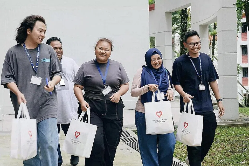 KELUARGA SUKARELAWAN: Setelah menyumbang bakti sebagai relawan, Cik Zawiyah Kosman (dua dari kanan) menarik suaminya, Encik Rosli Abdul Gani (dua dari kiri), dan anak-anak mereka - (dari kiri) Encik Muhd Zikry Rosli, Cik Nur Rindiani Rosli dan Encik Muhd Zaidan Idraki Rosli - menyertai beliau meluangka masa dan tenaga membantu masyarakat. - Foto-foto Pusat Sukarelawan dan Dermawan Nasional (NVPC)