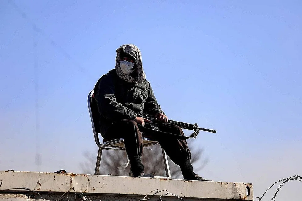 KUAT KUASA PERINTAH: Askar Taleban (atas) siap bersenjata mengawal di luar Universiti Kabul yang melarang kaum wanita daripada memasuki kampus. - Foto EPA-EFE 