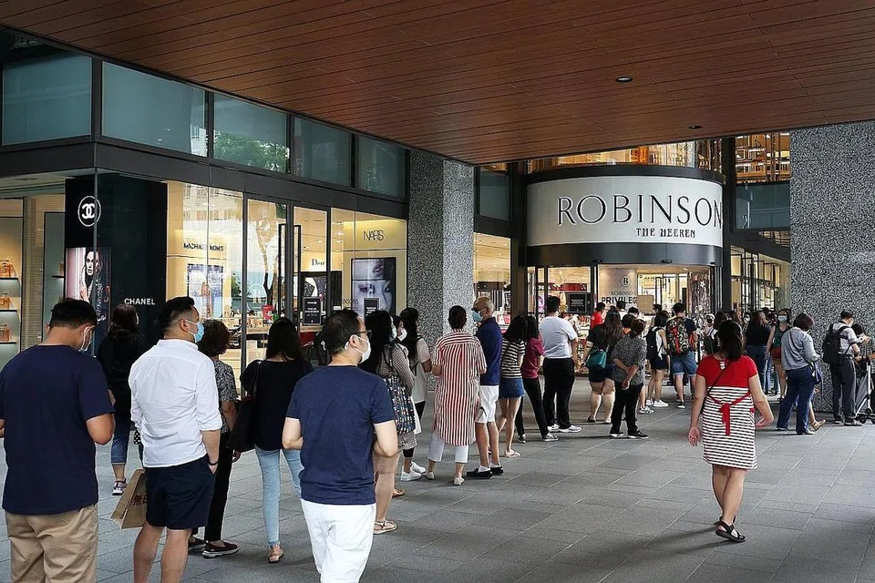 SANGGUP TUNGGU GILIRAN: Orang ramai dilihat beratur panjang di luar bangunan The Heeren di Orchard Road untuk memasuki gedung beli-belah Robinsons. Ketika wartawan Berita Minggu mengunjungi tempat tersebut semalam, barisan panjang dilihat sehingga kedai Apple Orchard Road, namun ia bergerak dengan agak pantas. - Foto ZAOBAO