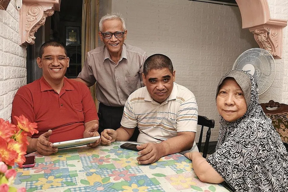 LEGA DAN SYUKUR: Encik Buang Ahmad Bakri, 70 tahun(berdiri) dan isteri, Cik Noorhayah Mohd Arrifin, 66 tahun (kanan) lega setelah menyertai Skim Dana Amanah Keperluan Khas untuk anak-anak mereka Encik Mohamed Halim Buang, 42 tahun (kiri), dan Encik Abdul Kadir Buang, 44 tahun (dua dari kanan), yang kurang upaya intelek. - Foto BH oleh KHALID BABA