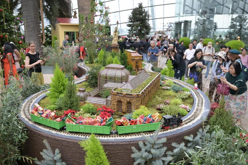 Sebuah kereta api miniatur melintasi model botani Konservatori Taman Botani Amerika Syarikat di Pertunjukan Kereta Api Krismas Gardens by the Bay. 