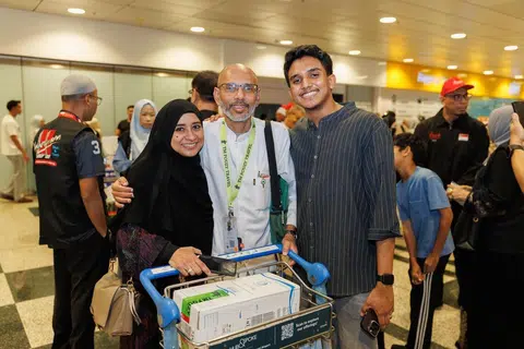 Anggota jemaah haji bersama TM Fouzy Travel & Tours, Encik Muhd Lotfi Murad Jarhom (tengah) disambut oleh anggota keluarganya, termasuk isterinya Shaikhah Fairiya Shaikh Mohsin Alkhatib (kiri), dan anak sulungnya, Encik Muhammad ‘Afif Muhd Lotfi Jarhom (kanan), di balai ketibaan Terminal 3 Lapangan Terbang Changi pada 1 Jun.