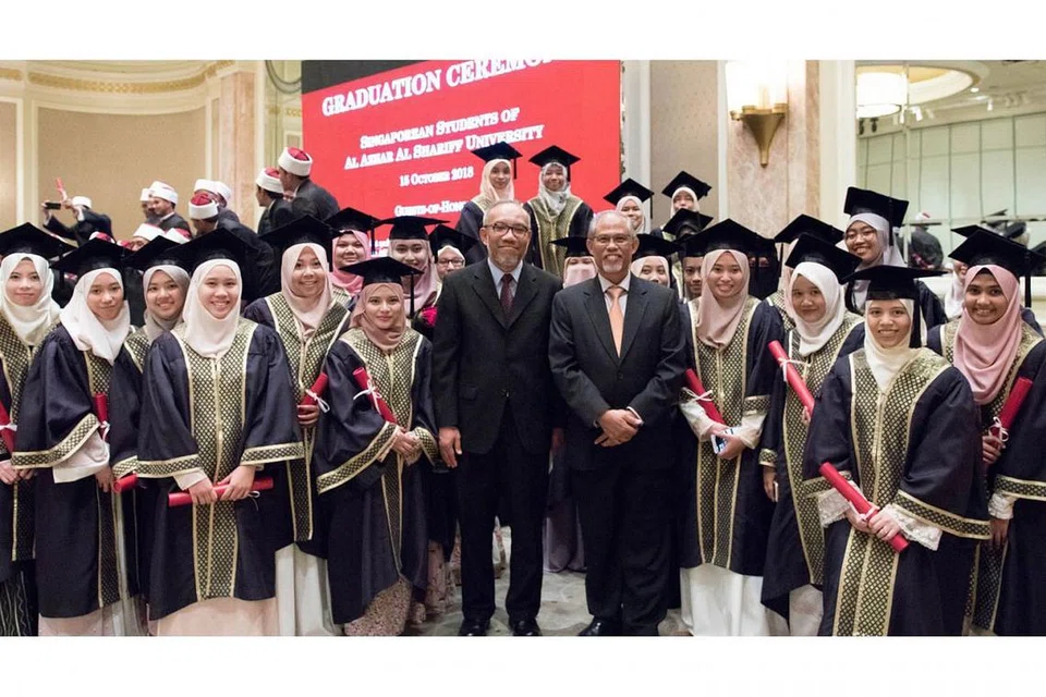 TAMAT PENGAJIAN: Encik Masagos Zulkifli (tali leher oren) dan Timbalan Ketua Eksekutif Muis Dr Albakri Ahmad (tali leher coklat) bergambar bersama siswazah Singapura di Universiti Al-Azhar. Sekitar 60 siswazah dari Singapura menerima ijazah mereka daripada Encik Masagos di acara tamat pengajian universiti tersebut. - Foto MUIS