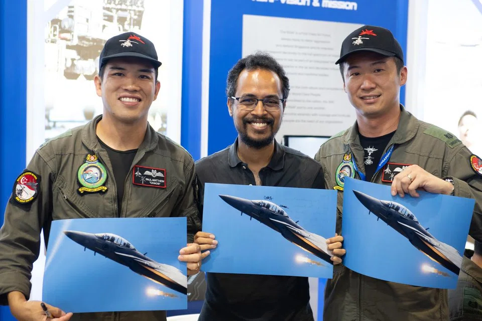 Encik Adam Maniam (tengah) bergambar bersama Mejar Paul-Matthew Lim (kiri) dan Mejar Lee Si Wei, dengan masing-masing memegang gambar yang Encik Adam petik.