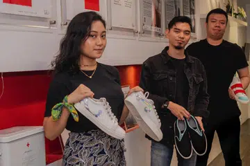 PENGALAMAN BARU: (Dari kiri) Cik Ami Azman, Encik Siraj Munir dan Encik Muhammad Syahid Mustapa bersama kasut sniker yang direka. - Foto BH oleh NUR DIYANA TAHA