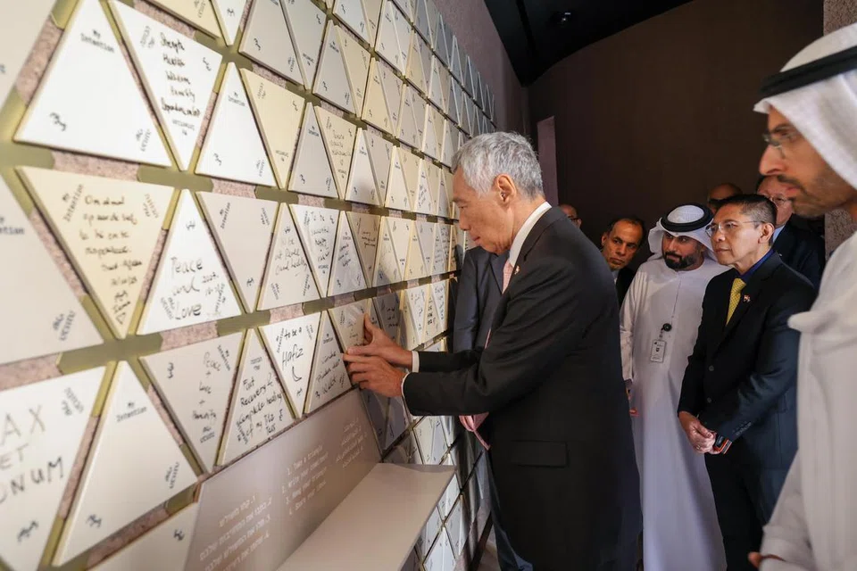 TULIS UCAPAN: Encik Lee menulis ucapan “Perpaduan dalam Kepelbagaian” di dinding hiasan di kompleks antara agama Abrahamic Family House.