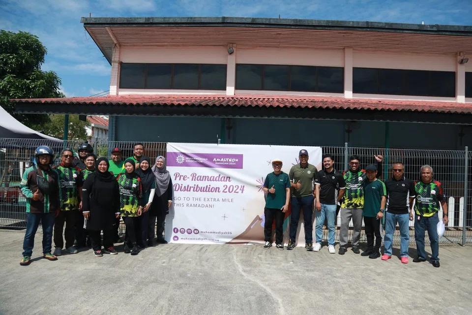 Presiden Muhammadiyah, Ustaz Mohd Azri Azman (enam dari kanan) bersama pekerja Muhammadiyah dan sukarelawan dari Grab ketika pengagihan barangan keperluan pra-Ramadan.