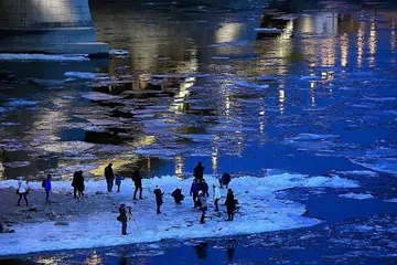SEMUA BEKU: Orang ramai mengambil gambar dan berdiri di atas kepingan ais yang membeku di Sungai Danube di Budapest, kelmarin. - Foto AFP