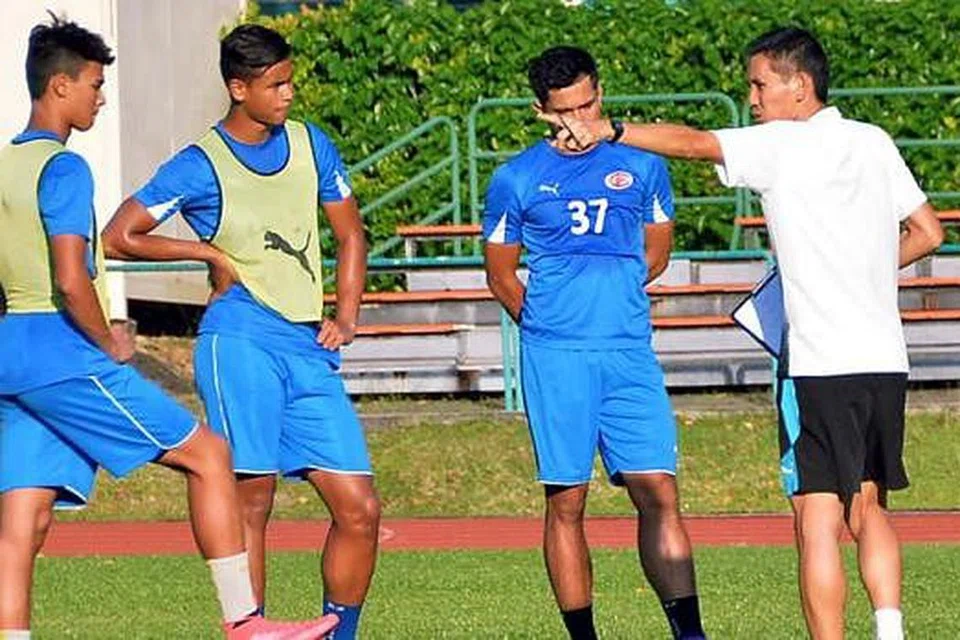 INGIN BUKTI KEUPAYAAN: (Dari kiri) Ikhsan dan Irfan serta seorang rakan sepasukan mendengar arahan jurulatih Phillipe Aw (berbaju putih) semasa latihan di Stadium Yishun baru-baru ini. - Foto KHALID BABA