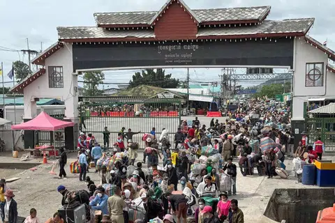 Gambar edaran yang diambil dan dikeluarkan oleh Kementerian Buruh Kemboja pada 6 Ogos 2025 ini menunjukkan pekerja migran Kemboja membawa barang-barang peribadi mereka ketika pulang dari Thailand susulan pertempuran sempadan, melalui Pintu Sempadan Antarabangsa Daung di wilayah Battambang.