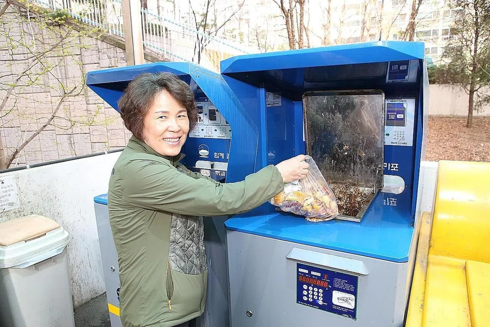 FIKIR SEBELUM MEMBAZIR: Warga Korea Selatan Cho Sung Ja menggunakan sistem pembuangan sisa makanan RFID yang dapat menimbang jumlah sampah yang dibuang dan mengenakan bayaran sewajarnya. - Foto fail ST