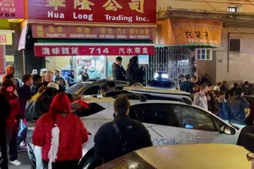 Orang ramai mengerumuni sebuah teksi pandu sendiri, Waymo, selepas ia tersasar masuk ke ruang yang penuh sesak dengan orang ramai yang sedang menyambut Tahun Baru Cina di San Francisco, Amerika Syarikat. 