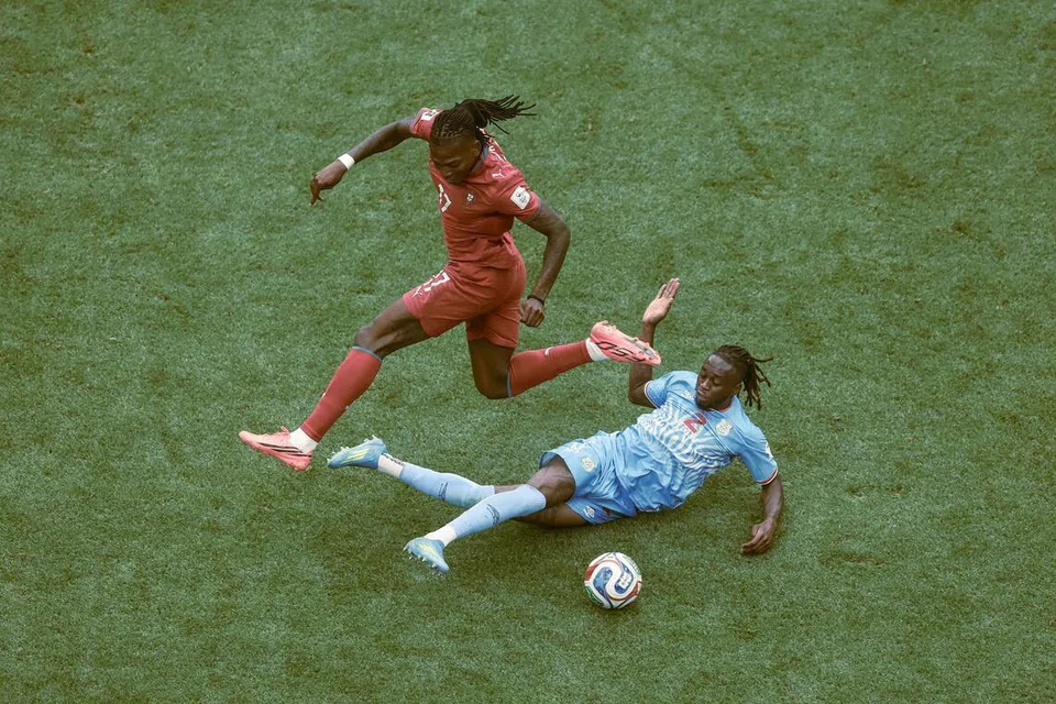 Bek kanan DR Congo, Aaron Wan-Bissaka (kanan), merebut bola daripada pemain sayap Portugal, Rafael Leao (kiri), dalam aksi perlawanan Kumpulan K di Stadium houston pada 17 Jun.
