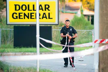 ANGKARA PERKAUMAN: Seorang anggota polis memasang pita di sekitar kedai Dollar General di Jacksonville, Florida – tempat seorang lelaki bersenjata menembak mati tiga orang kulit hitam pada Sabtu.