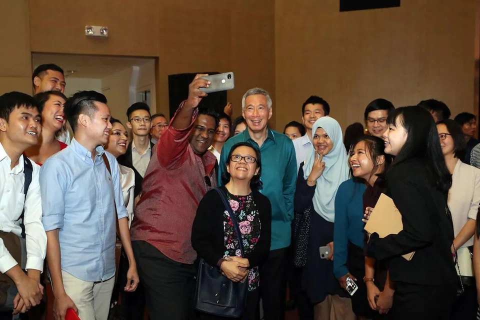 BERGAMBAR BERSAMA: Sekumpulan hadirin di Rapat Hari Kebangsaan di Institut Pendidikan Teknikal (ITE) Kolej Central kelmarin merebut peluang bergambar dengan Perdana Menteri Lee Hsien Loong (tengah) di akhir acara itu. - Foto BH oleh GAVIN FOO