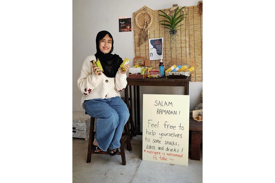 TIDAK SUSAH BANTU ORANG LAIN: Cik Qistina Nabilah Rizal menyediakan meja snek diluar rumahnya di Woodlands untuk sesiapa sahaja yang memerlukan, terutama pekerja penghantaran makanan yang bekerja ketika masuk waktu berbuka.
