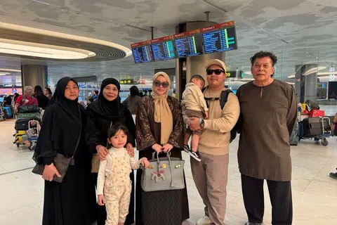 Cik Nur Fadliah Kamis (tiga dari kiri) bersama suami, Encik Mohamed Abbas Abdul Kader (dua dari kanan), bersama dua anak kecil mereka, disambut baik oleh ibu, Cik Aini Kemat (kiri) dan ibu bapa mentuanya, Encik Abdul Kader Jumali (kanan), dan Cik Aisha Sharif di Balai Ketibaan Terminal 2 Lapangan Terbang Changi pada 11 Mac.