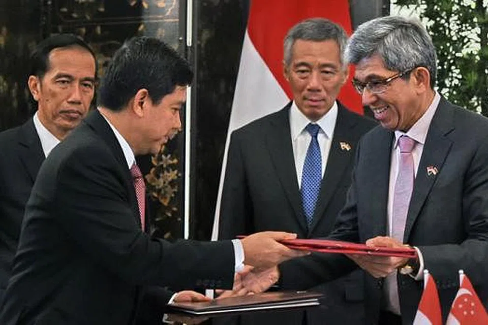 PAKATAN DUA NEGARA: Presiden Indonesia, Encik Joko Widodo (belakang kiri), dan Perdana Menteri Singapura, Encik Lee Hsien Loong (belakang kanan), menyaksikan perjanjian yang dimeterai bagi kerjasama dalam elektronik pemerintah yang ditandatangani Menteri Perhubungan dan Penerangan Singapura, Dr Yaacob Ibrahim (kanan), dan Menteri Pembaharuan Pentadbiran dan Birokratik Indonesia, Encik Yuddy Chrisnandi. - Foto AFP