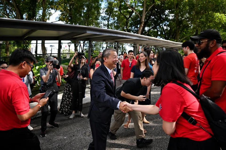 BERAMAH MESRA: Encik George Goh, yang mengambil borang permohonan bagi mendapatkan Sijil Kelayakan untuk bertanding di Pilihan Raya Presiden, bertemu penyokongnya yang mengenakan pakaian berwarna merah di luar pejabat Jabatan Pilihan Raya pada Selasa pagi.
