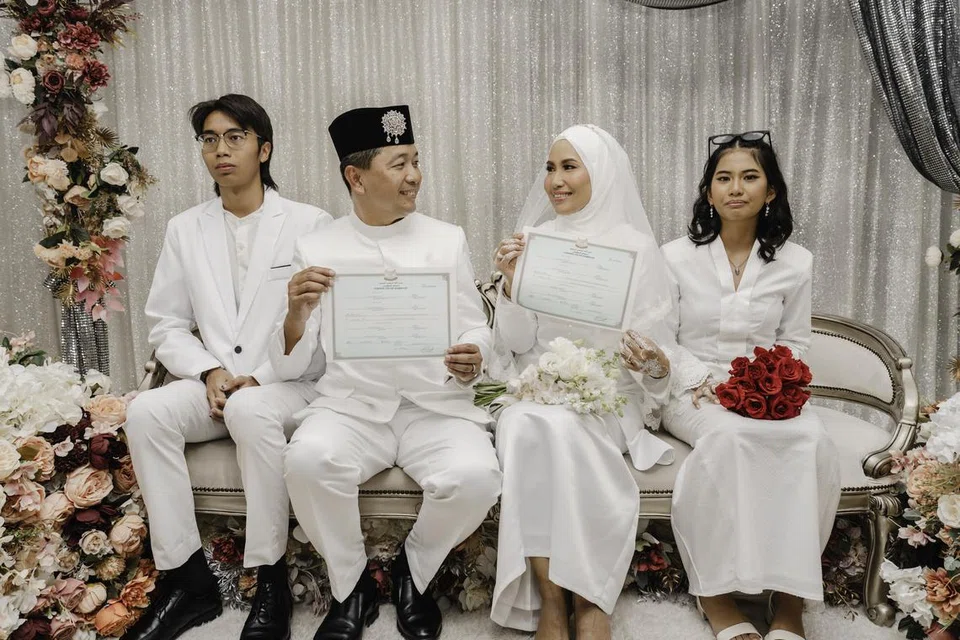 Nina Fevriena dan Zack Zuraini bergambar di atas pelamin bersama anak-anak mereka, Haedy Raoulf, 19 tahun (paling kiri), dan Helena Rose, 14 tahun, yang disatukan kembali dalam majlis pernikahan pasangan itu pada 2 Februari lalu.