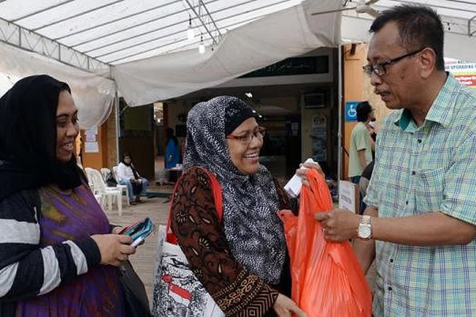 DIMANFAATKAN RAMAI: Daging korban beku yang diagih Encik Paiman (kanan) dimanfaatkan penerima zakat seperti Cik Norien (kiri) serta rakannya Cik Faridah Mohd Isa (tengah). - Foto TAUFIK A. KADER